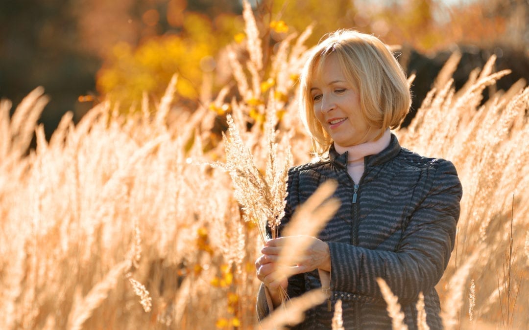Lady picking wheat in a field of wheat